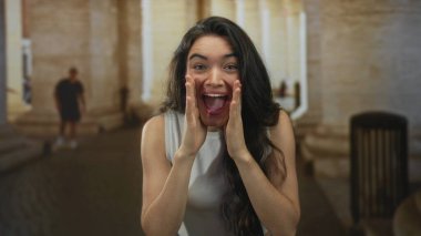 Beyaz atletli bir kadın suni teneffüs için suni teneffüs yapıyor. Güneşli eski kasaba caddesinde, ağzı açık bir şekilde bağırıyor..