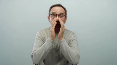 Olgun bir adam beyaz arka planda elleri ağzında bağırıyor.
