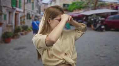 Sokakta dürbünlü el dürbünü kullanan bir kadın gözlüklü, merak dolu seyahat tutkusu.