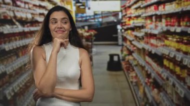 Süpermarket binasında el pençe üzerinde duran genç kadın, sessiz yansıması.