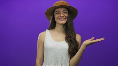 Stüdyoda boş alan gösteren el hareketleriyle gülümseyen genç İspanyol kadın, iyimserlik..