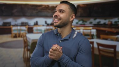 Restoranda gülümseyen ve el sıkışan genç adam ahşap masa ve sandalyelerin yanına; sevinç minnettarlığı.