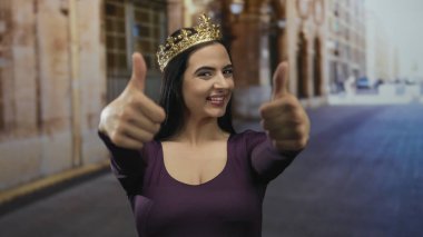 Taçlı İspanyol kadın, güneşli bir sokakta gülümserken, açık şehir ortamında neşe ve güveni yakalıyor..