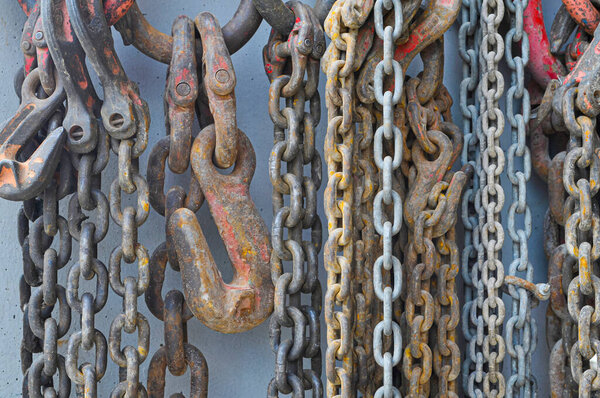 used chains hanging on cement wall inside a factory