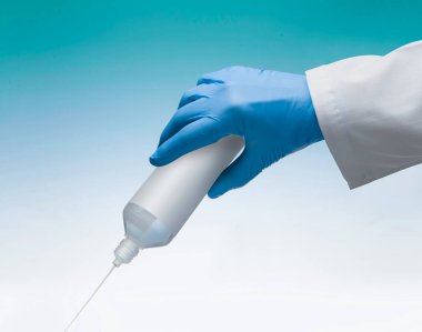 nurse's hand with glove while pouring liquid from a bottle