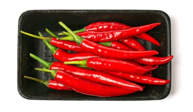 Beyaz bir arka planda izole siyah tek kullanımlık plastik ambalaj kutusunda taze kırmızı Chili Pepper. Üst görünüm, düz Lay görüntü