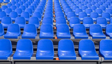 Stadyum arka planında boş mavi koltuklar
