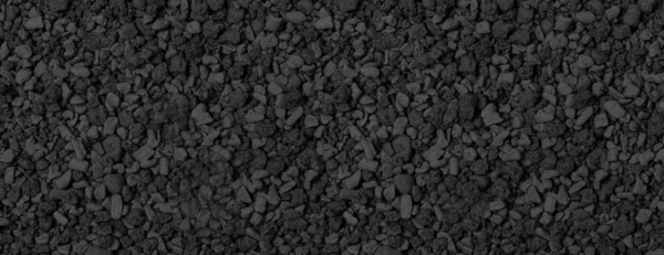 black small rocks ground texture. black small road stone background.