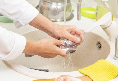 Kadın eli bulaşık yıkıyor.