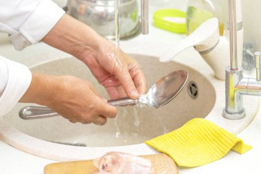 Kadın eli bulaşık yıkıyor.