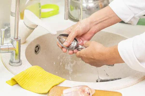 women's hands wash dishes kitchen