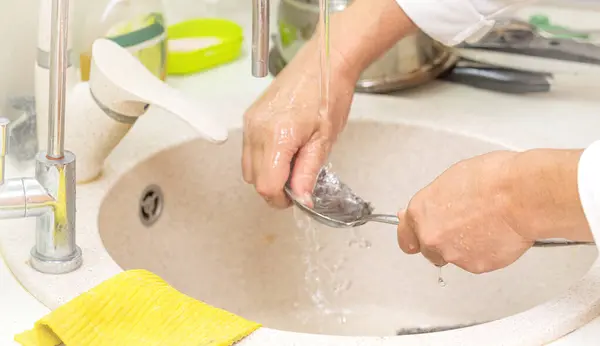 women\'s hands wash dishes kitchen
