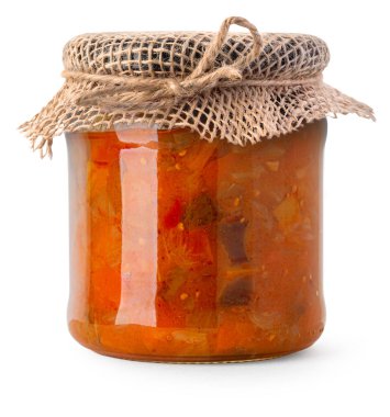 Bir kavanoz ev yapımı sebze yahnisi ve sade çuval bezi kapağı kesilmiş.