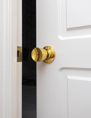 Beyaz ahşap kapı tokmağı karanlık odaya açılıyor. Gizem, geçiş ve yeni başlangıçlar kavramı.