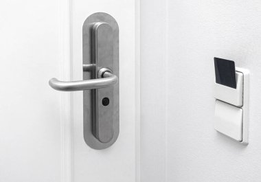 Anahtar kartı bir otel odasının kapı kilidine yerleştirilmiş. Elektrik düğmesi, enerji tasarrufu kavramı ve modern erişim kontrolü var.