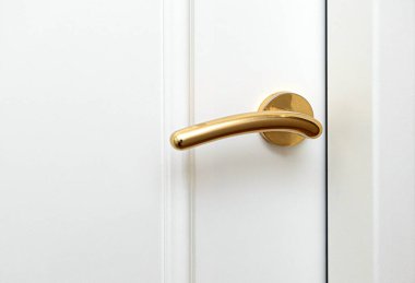 Beyaz bir kapının üzerinde altın bir kapı kulpu var. Lüks ve entelektüeli simgeliyor.