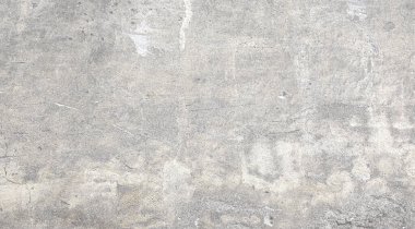 Yaş, aşınma ve çeşitli kusurlarla işaretlenmiş, arka plan ve tasarım projeleri için uygun desenli bir yüzeyi ortaya çıkaran gri beton duvarın yakın görüntüsü
