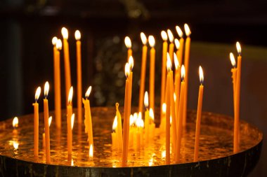 Kilisede mum yakmak, karanlığı aydınlatmak, ruhani bir atmosfer yaratmak.