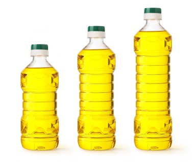 Beyaz arka planda altın sarısı sebze yağı standı içeren üç farklı boyutta temiz plastik şişe.