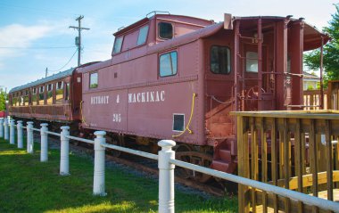 Passenger cars and old caboose stored at  historic Standish Michigan railroad depot