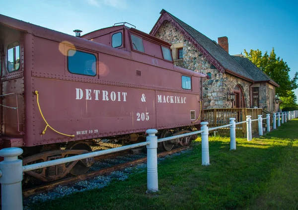 Passenger cars and old caboose stored at  historic Standish Michigan railroad depot