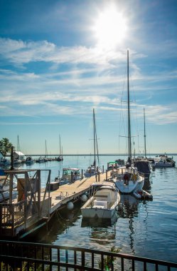 Boat Marina pier with sail boats tied under morning summer un shine