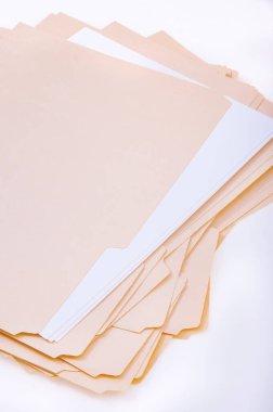 Birden fazla boş bej dosya dizini gevşek bir yığın halinde üst üste bindirilmiş. Organizasyon kavramlarının, ofis malzemelerinin, belgelerin veya idari görevlerin taşınması için ideal.