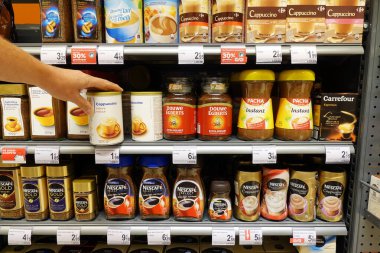 AĞUSTOS 2018: Alışveriş yapan kişi özel bir kapuçino kutusu satın alır. Markalarla dolu raflar Carrefour süpermarketinde hazır kahve ürünleri..