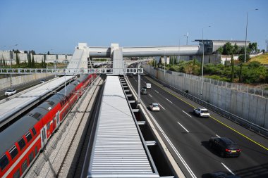 RA 'ANANA, ISRAEL MAYIS 2023: 531 no' lu karayolu üzerindeki yaya köprüsü, Sharon Demiryolu 'nun bir parçası olan Ra' anana Batı tren istasyonu peronuna..