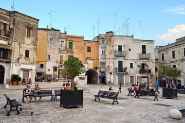 BARI, İTALYA 2023: Apulia 'nın eski kenti Bari' deki Piazza Federico II di Svevia 'da bir bankta yaşlı kadınların resim sahnesi.