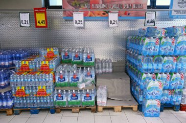 BARI, İTALYA - 20 Temmuz 2023: 6 'lı paketlerin olduğu paletler indirimli bir süpermarkette doğal maden suyu.