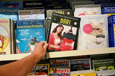 BARI, ITALY - HAZİRAN 2023: Bari ile ilgili İnsan İlgi Dergisi, havaalanındaki bir hediyelik eşya dükkanında farklı İtalyan dergilerinin teklifleri arasında