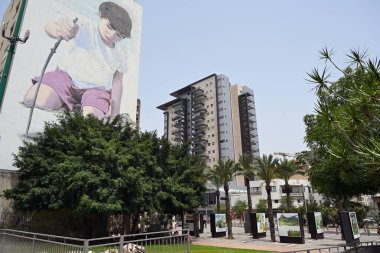 HADERA, ISRAEL - Mayıs 2023: New York merkezli ressam BKFoxx 'un bir apartmanın yanındaki küçük bir çocuğun büyük duvar resmi