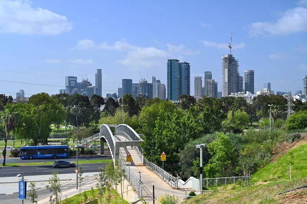 TEL AVIV-YAFO, ISRAEL - MAYIS 2023: Rokach Bulvarı üzerinden Yarkon parkına uzanan yaya köprüsü Ramat Gan ve Tel Aviv 'in yüksek binaları