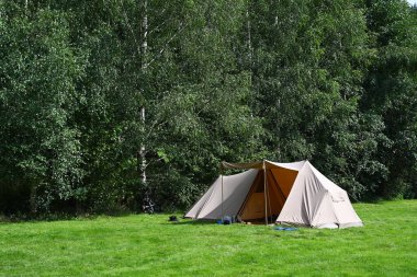 Belçika Ardennes 'te kamp alanı. Çimlerin üzerinde pamuk kumaştan yapılmış bir branda barınağı var..