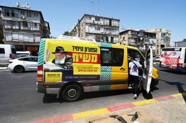 BNEI BRAK, ISRAEL - Mayıs 2023: Habad Rebbe 'nin büyük resmine sahip taksi minibüsü. İbranice metin: 'Tek çözüm, MESSIAH, mitzvot ve iyi eylemler ekleyin, ve kurtuluş getirildi'