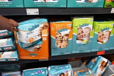 BELGIUM - AUGUST 2023: Shopper select Bebino private label brand disposable diapers of shelves various sizes diapers in a ALDI supermarket clipart