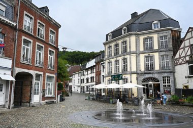 SPA, WALLONIA, BELGIUM - AUGUST 2023: Restaurant and terrace on a cozy square with fountain in the center of Spa clipart