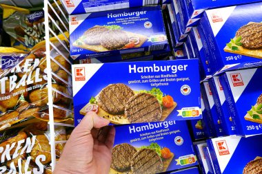 ALMANY - Nisan 2024: Alışveriş yapan kişi dondurulmuş hamburgerler, bir Kaufland Hypermarket dondurucusundan sığır eti.