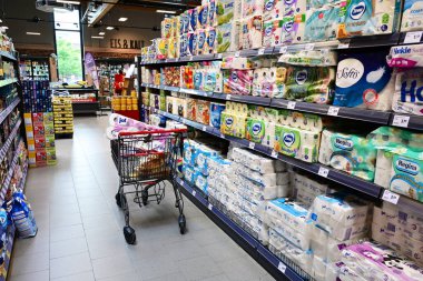 ALMANY HAZİRAN 2024: Bir REWE süpermarketinde alışveriş arabası ve kağıt mendil ürünleriyle dolu koridor.