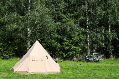 Belçika Ardennes 'te kamp alanı. Çimlerin üzerinde pamuk kumaştan yapılmış bir branda barınağı var.