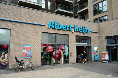 DENDERMONDE, FLANDERS, BELGIUM AĞUSTOS 2024: Müşteri günlük alışveriş için Albert Heijn süpermarketine girer. AH, Ahold Delhaize 'in bir parçası olan bir Hollanda süpermarket zinciri..