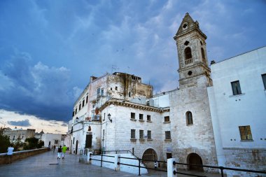 BARI, ITALY - JULY 2023: Street view of Via Venezia featuring of buildings, houses and the 'Torre della SS Annunziata' on the old city's medieval walls during blue hour clipart