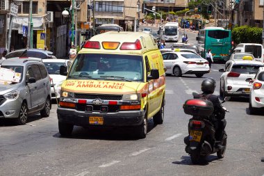 BNEI BRAK, ISRAEL - MAYIS 2023: Bnei Brak 'ta büyük bir cadde olan Haham Akiva Caddesi' ndeki trafikte ambulans sürüyor