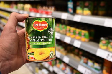 ALMANY - MAYIS 2025: Alışveriş yapan kişi Alman REWE süpermarketinden Del Monte marka bir konserve meyve kutusu seçti.