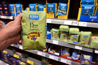 GERMANY - MAYIS 2025: Alman REWE süpermarketinde organik üretilmiş Fusilli makarna olan De Cecco marka Bio etiketini seçen müşteri.