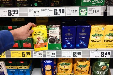 GERMANY - Mayıs 2025: Adil ticaret ve bir REWE süpermarketinde organik etiketli kahve markaları. Adil ticaret, gelişmekte olan ülkelerdeki üreticilerin iyi ticaret yapmalarına yardımcı olmak için tasarlanmış bir düzenlemedir..