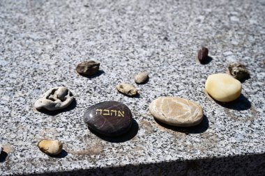 İbranice 'de' AH-HAV-VA 'anlamına gelen' aşk 'anlamına gelen küçük bir anıt taşı. Geleneksel Yahudi kullanımı: Yahudiler sevdiklerinin mezarlarına hatırlandıklarının bir işareti olarak küçük çakıl taşları koyar.