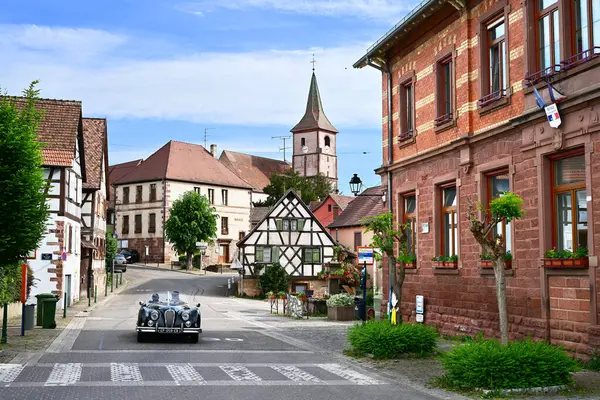 BALBRONN, ALSACE, FRANCE - MAYIS 2025: Klasik bir araba turunda turistler Alsace 'in şarap yetiştirme bölgesinde tipik yarı kereste evlere sahip bir köy.