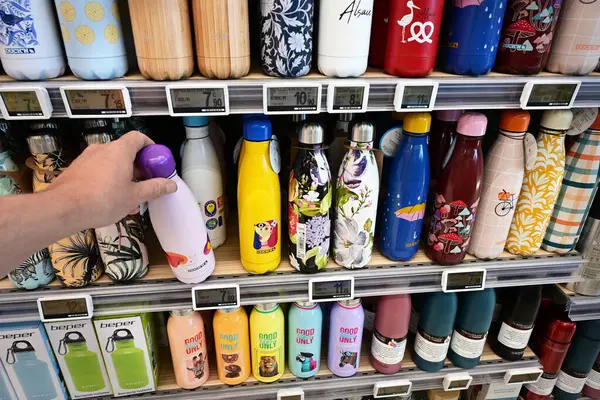 ALSACE, FRANCE - MAYIS 2025: tüketici bir ekran izole şişe seçin çeşitli renklerde vakum tüpleri ve bir E.Leclerc Hypermarket ev tasarımları aralığı.